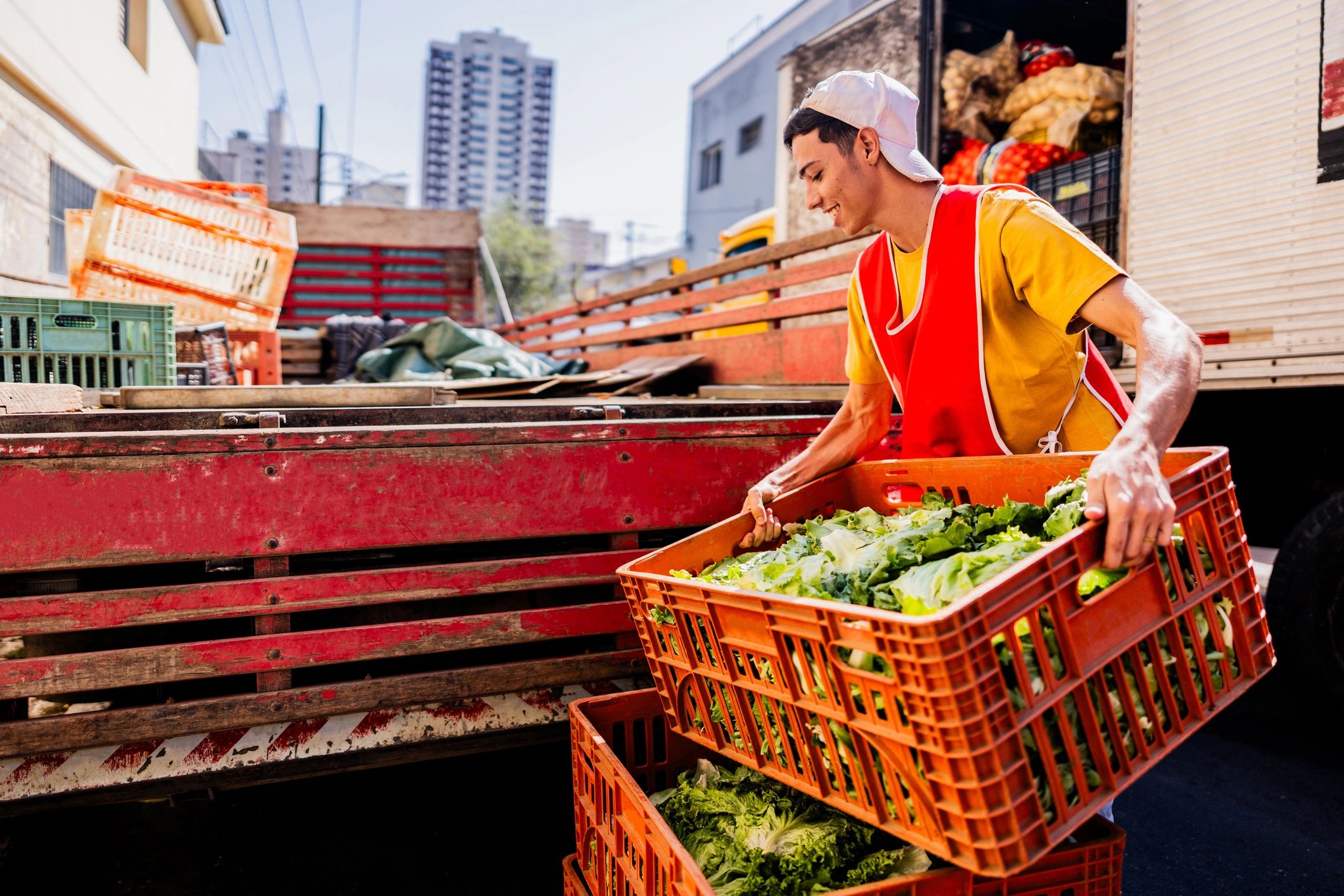 Worker unloading boxes of vegetables for delivery